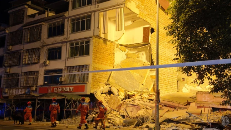 Los equipos de rescate caminan junto a un edificio dañado tras un terremoto en la aldea de Taiyang, en Liuzhou, Región Autónoma Zhuang de Guangxi, China , el 18 de mayo de 2026.