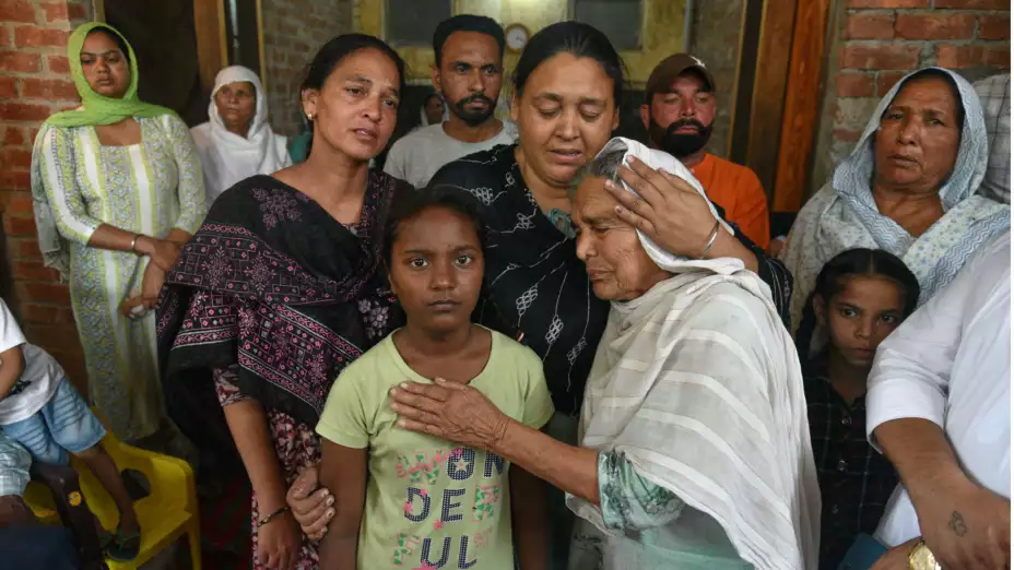 Familiares de una víctima tras beber licor tóxico en India.