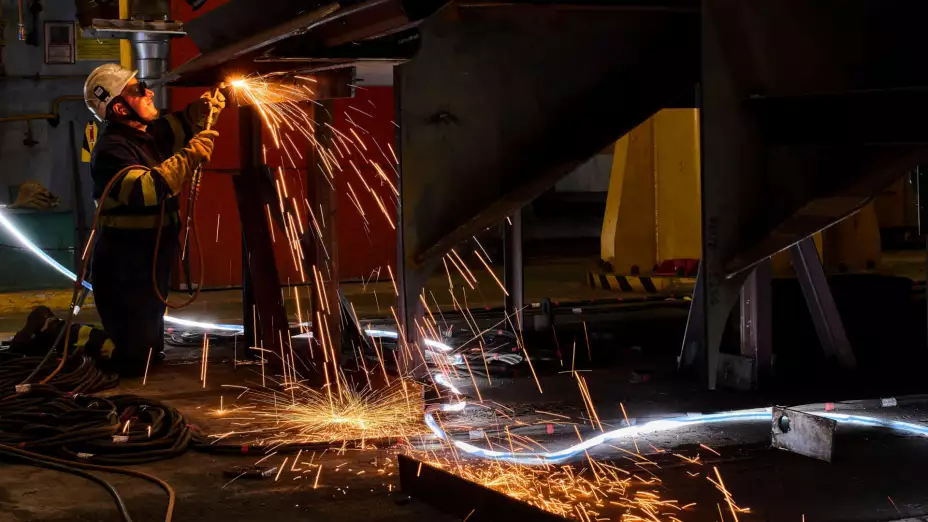 Trabajador español suelda el fuselaje de una fragata.