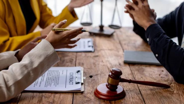 Dos abogadas hablan con un cliente en una oficina.