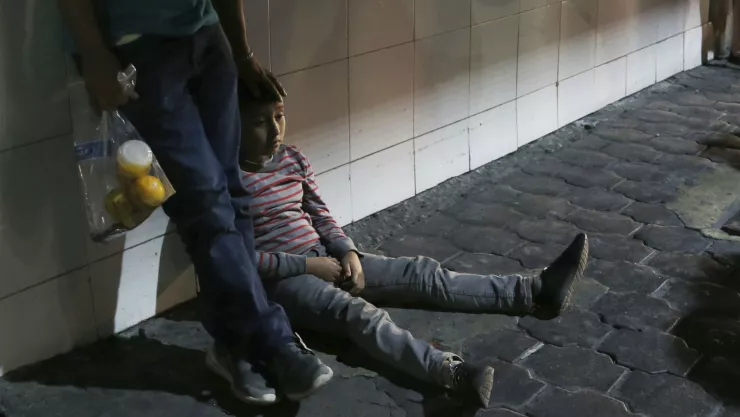 En esta imagen, tomada el 18 de julio de 2019, un niño migrante y su padre esperan junto luego de que las autoridades migratorias mexicanas los trasladaron en autobús desde Nuevo Laredo. Imagen, AP.
