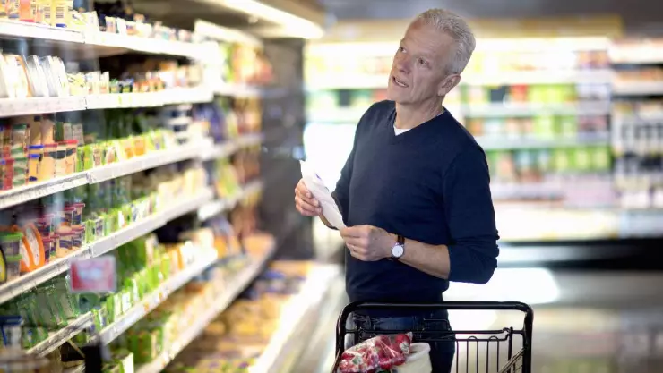 Hombre comprando en supermercado de Estados Unidos, donde la inflación sigue a la baja