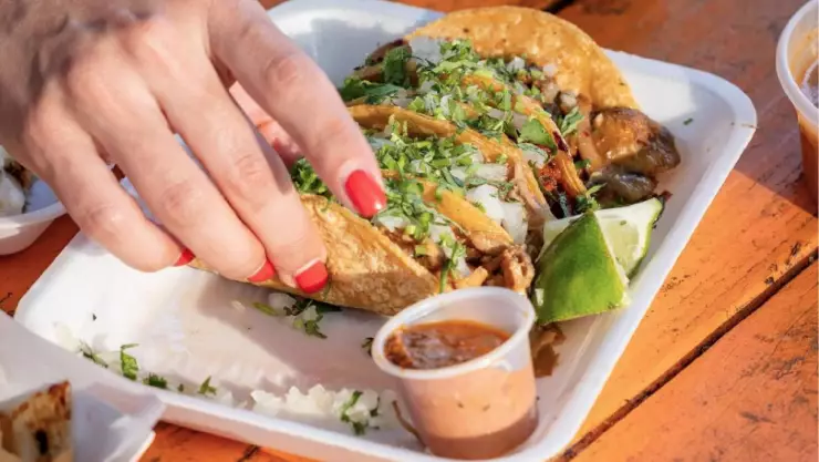 una mujer a punto de saborear unos deliciosos tacos
