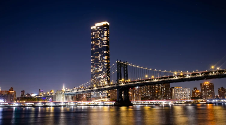 El puente de Brooklyn en el anochecer con las luces encendidas y la ciudad de Nueva York de fondo