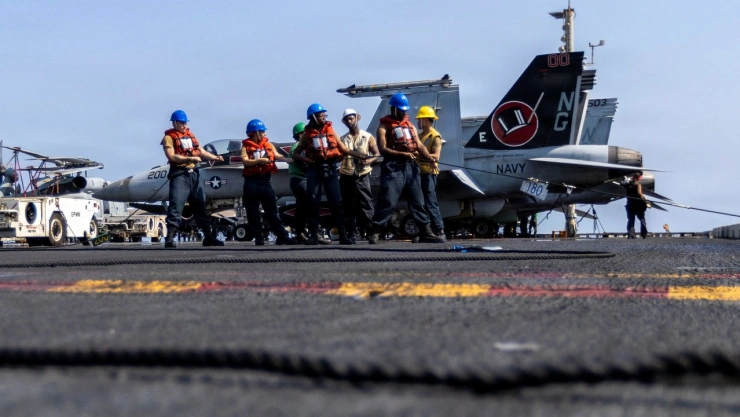 Marineros de la Armada de EE. UU. tiran de una cuerda durante una operación de reabastecimiento de combustible en alta mar en la cubierta de vuelo del portaaviones de clase Nimitz USS Abraham Lincoln durante el ataque de la Operación Furia Épica contra Irán desde una ubicación no revelada el 10 de marzo de 2026.