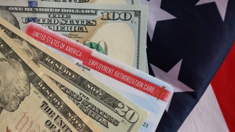 Una autorización de empleo en Estados Unidos junto a dólares