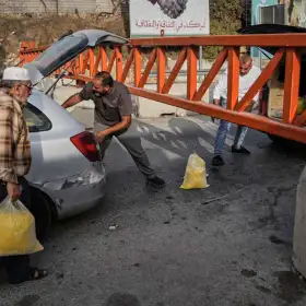 Palestinos frente a una barrera militar que cierra el paso en Hebrón, Cisjordania.