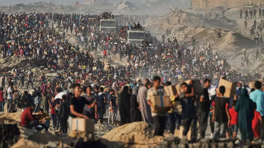 Personas con cajas de comida repartidas por la ACNUR en Gaza.