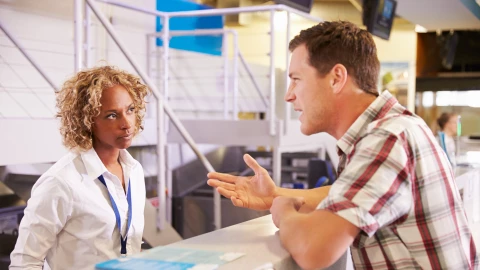 Un pasajero se queja con una trabajadora de una aerolínea estadounidense