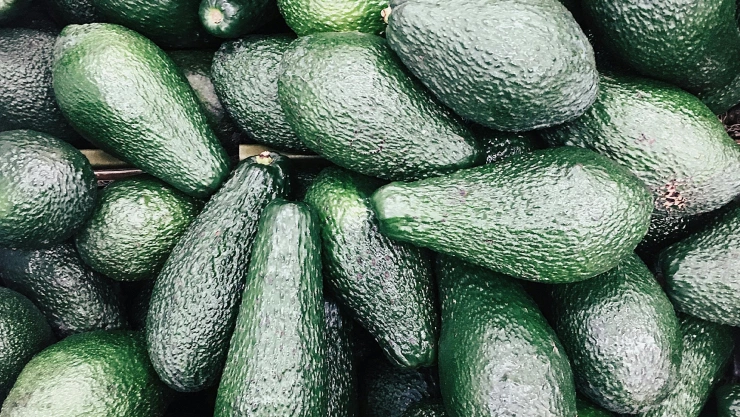 Aguacates apilados y amontonados sobre una superficie