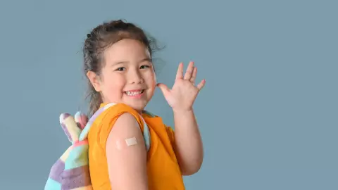 Una ni&ntilde;a feliz luego de haber recibido sus vacunas para empezar la escuela