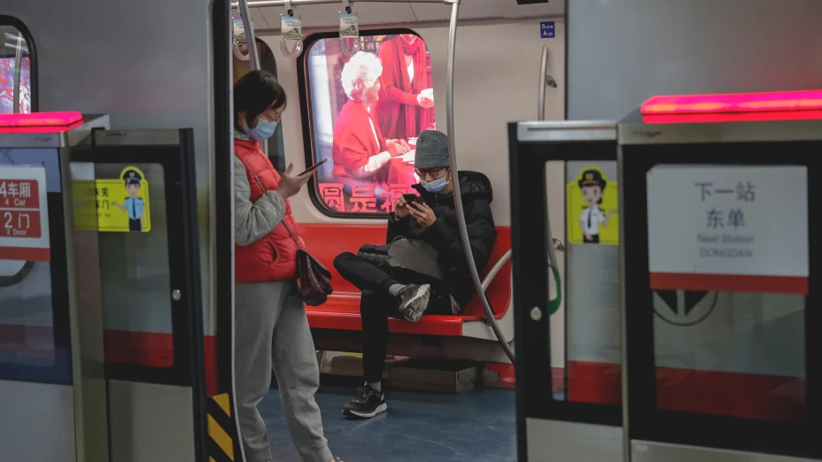Chinos con celulares en Metro de Beijing