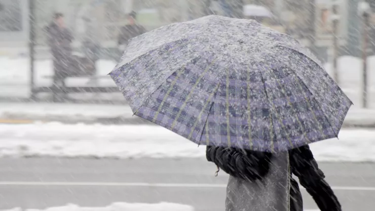 Persona bajo la nieve con un paraguas
