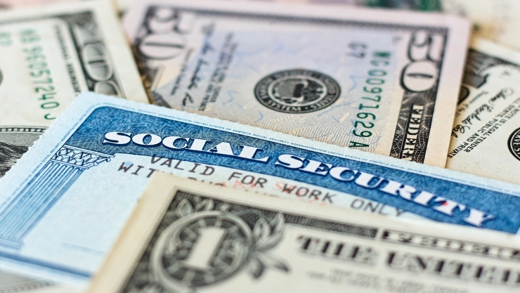 un concepto de dólares junto a la tarjeta del Seguro Social