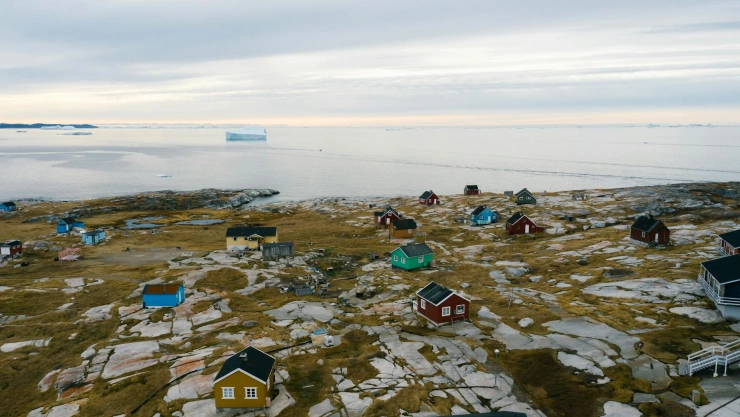 Panorámica del pueblo de Tiniteqilaaq, Groenlandia. Al fondo se ve un iceberg en el mar