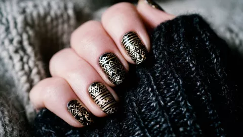 diseño uñas negras con mano alzada dorado