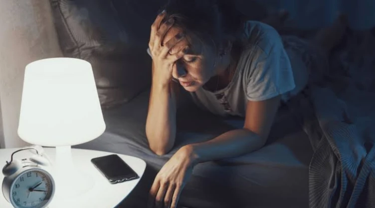 Una persona que no puede dormir bien durante la noche y con una lámpara encendida