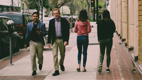 Cuatro persona caminado sobre la banqueta