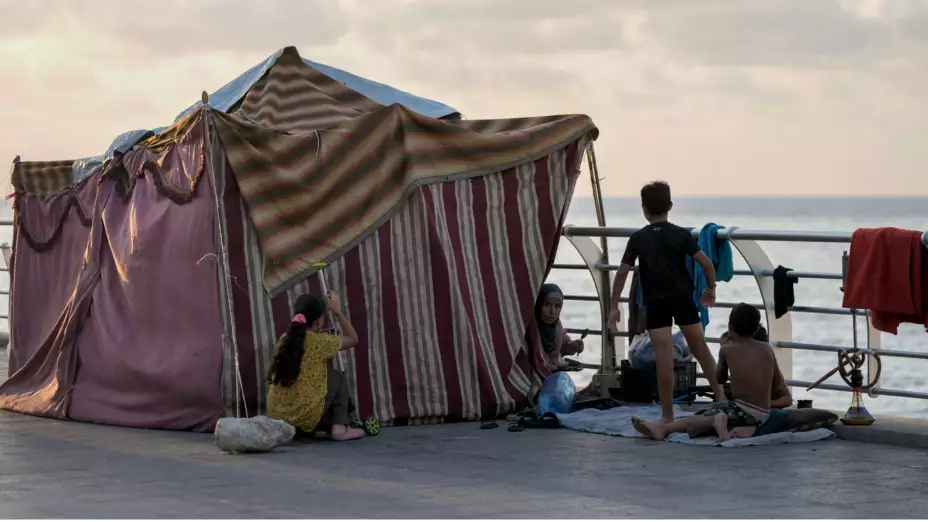 Familia libanesa desplazada huye de ataques aéreos israelíes.