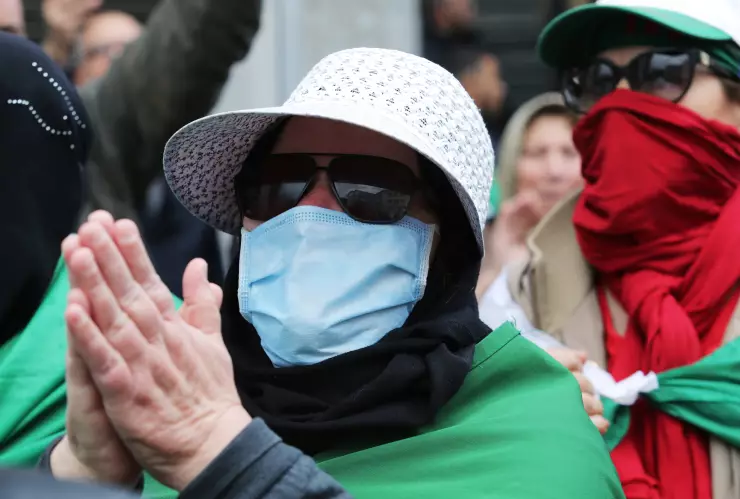A demonstrator wearing a face mask gestures during an anti-government protest in Algiers