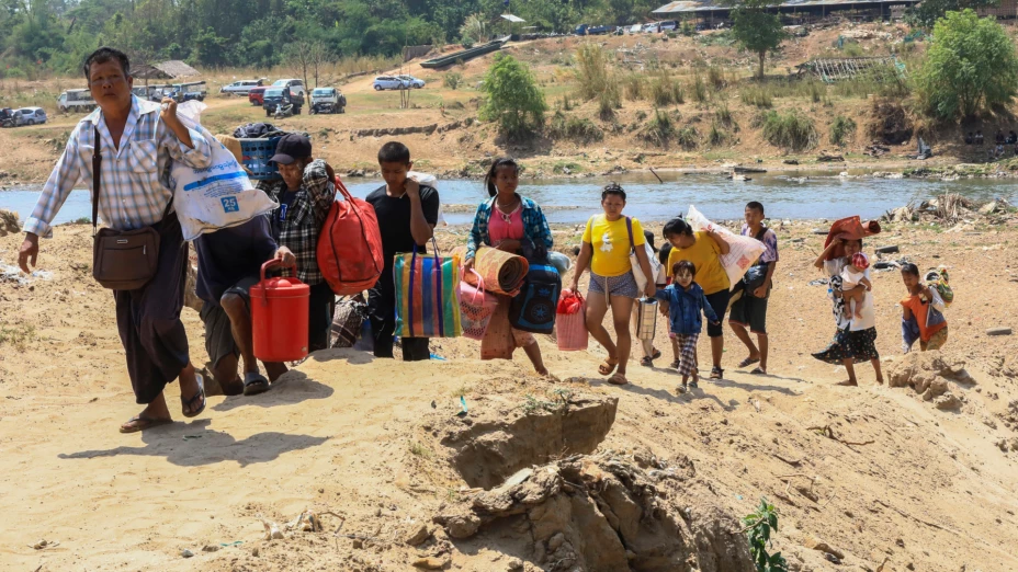 Personas cruzan el río Moei en su huida de Myanmar hacia Tailandia.