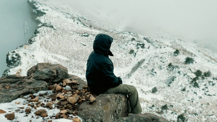 Persona sentada en piedra de montaña nevada Cofre de Perote en Veracruz