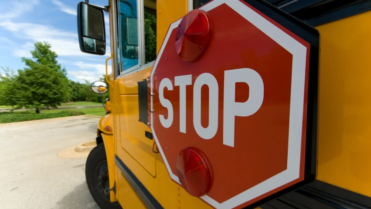 Un bus escolar con un cartel para parar