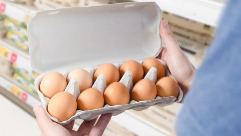Cliente revisa huevos en supermercado