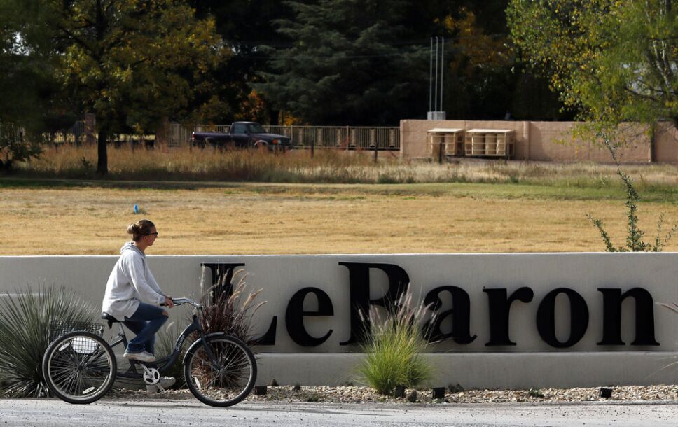 Una mujer pasa en bicicleta por delante del cartel de Colonia LeBarón, una comunidad establecida por miembros de la familia extendida LeBarón en el estado de Chihuahua, en el norte de México, el 6 de noviembre de 2019. Imagen: AP