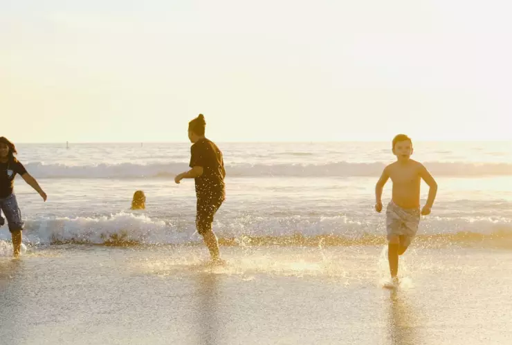 Una familia feliz disfrutando de la playa por las vacaciones de marzo 2025.