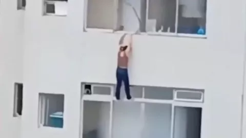Mujer queda colgada de edificio