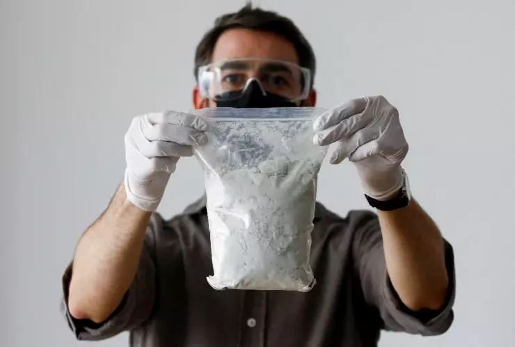 Hombre sostiene bolsa transparente con precursores de fentanilo.