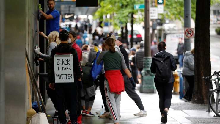 Community members help with cleanup efforts the morning after a rally against the death in Minneapolis police custody of George Floyd, in Seattle