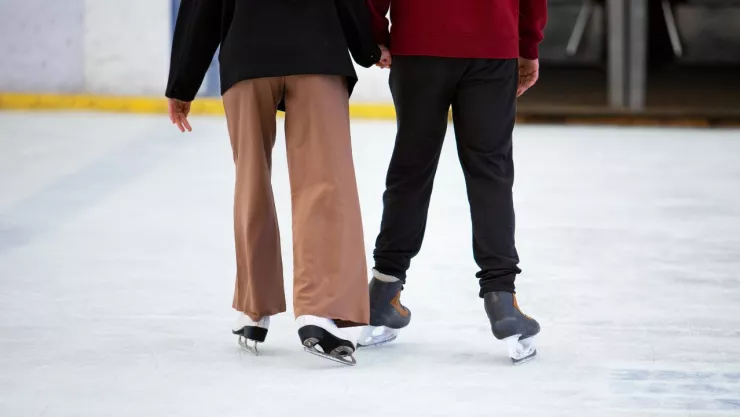 dos personas patinando en una pista de hielo