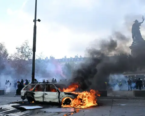 Un auto arde en París durante una protesta contra el alto costo de vida.