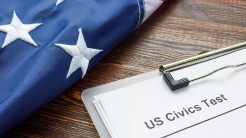 Un examen de cívica junto a una bandera de Estados Unidos.