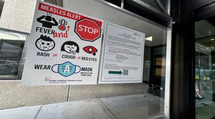 Un cartel de alerta sobre el sarampión cuelga a la entrada del Centro Médico Infantil Cohen en New Hyde Park, Nueva York, el 14 de marzo de 2025.
