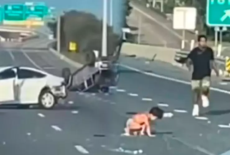 Niños en pañales en carretera con carros accidentados de fondo