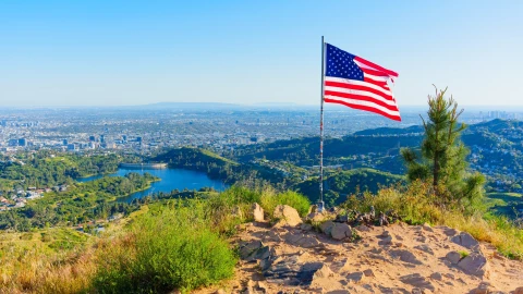 Panorámica de la ciudad de Los Ángeles, California, con una bandera estadounidense.