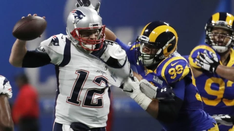 Tom Brady de los New England Patriots en acción con Aaron Donald de Los Angeles Rams.