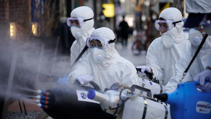 Empleados de una empresa de servicios de desinfección desinfectan un distrito comercial en Seúl, Corea del Sur, el 27 de febrero de 2020