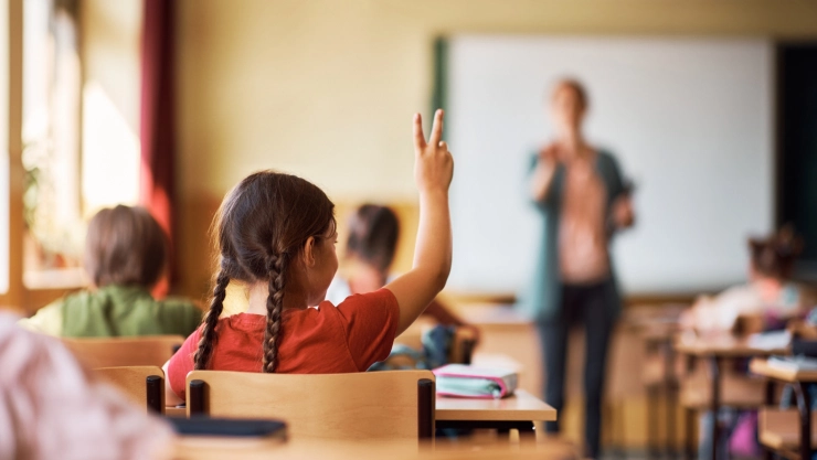 Alumnos en un aula con una maestra.