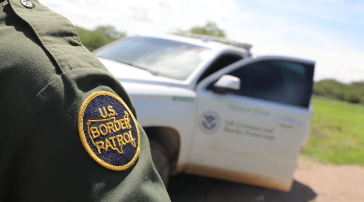 Agente de la CBP frente a patrulla.
