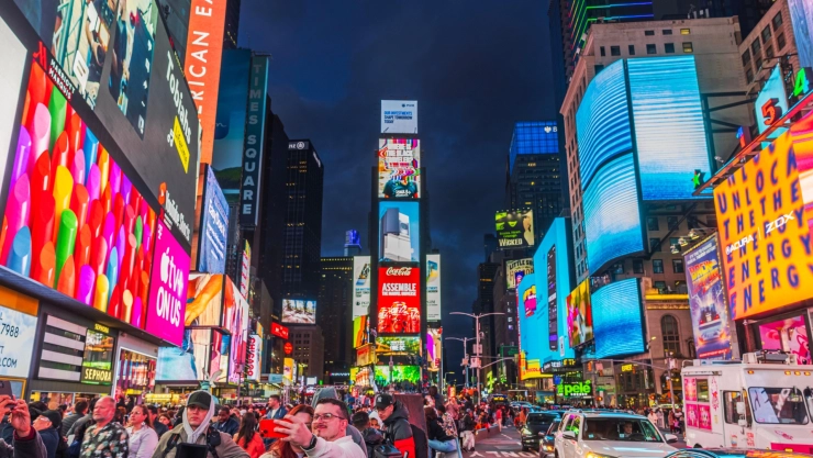 El Time Square de noche, con los turistas paseando por las calles y las grandes pantallas con publicidades se apoderan del paisaje