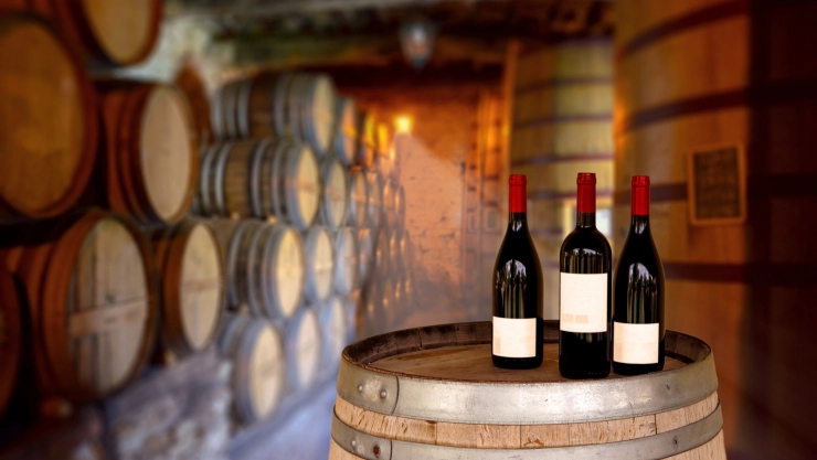Tres vinos arriba de un barril en una empresa vitivinícola