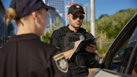 Dos oficiales multan a un conductor.