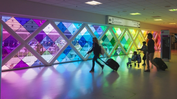 una familia camina por los pasillos del colorido aeropuerto