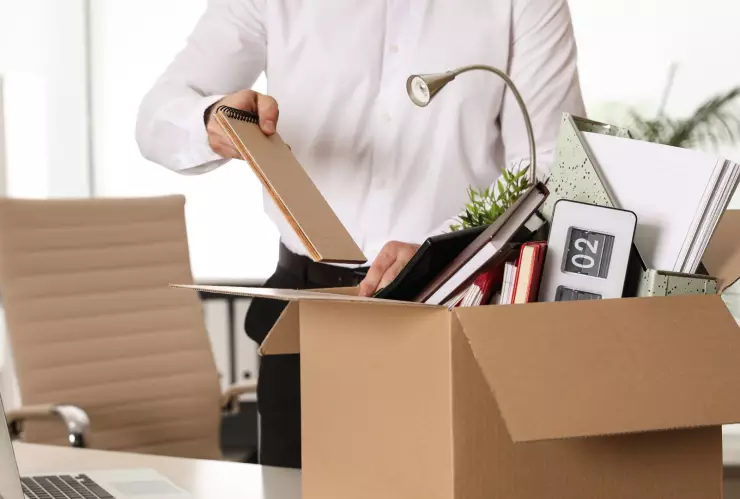 Un empleado despedido mete sus cosas en una caja.