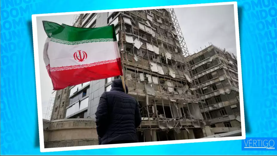 Un hombre con una bandera iraní tras un ataque en Teherán, Irán.