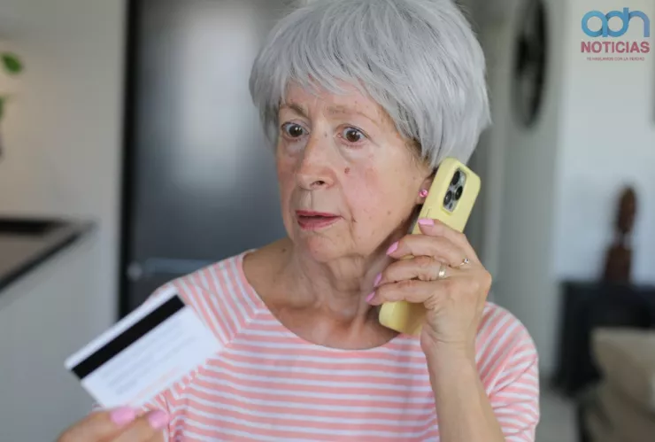 Una mujer atiende una llamada y queda sorprendida con lo que le dicen.